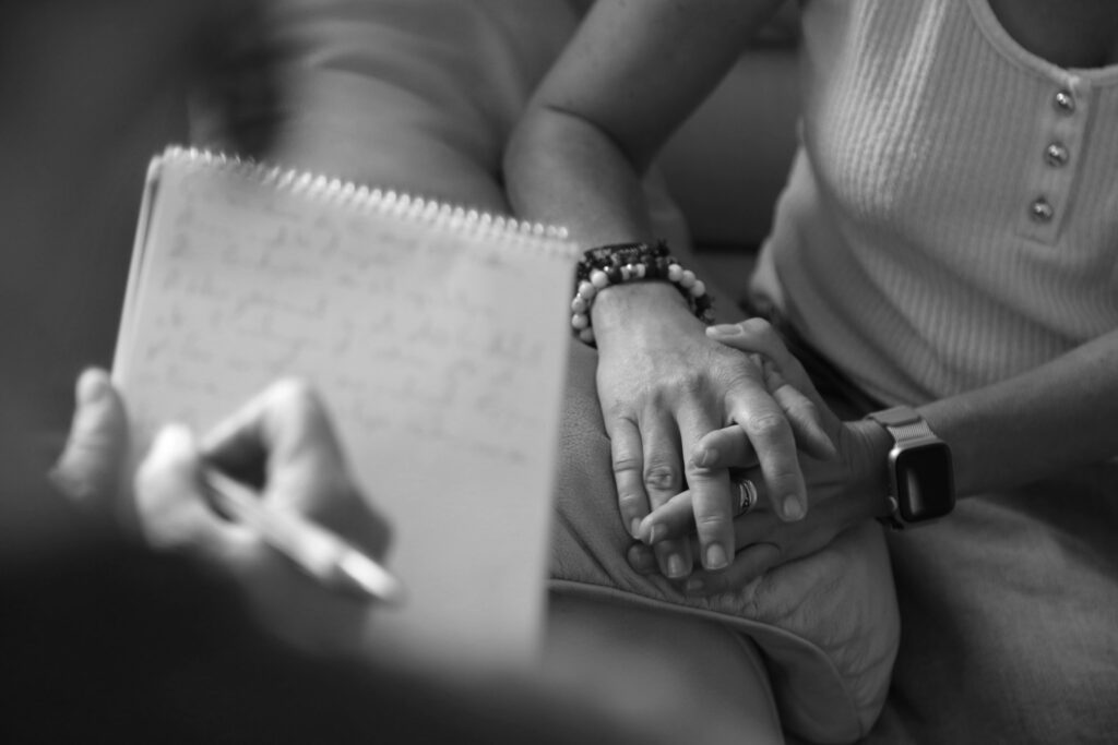 Une personne prend des notes pendant qu'une autre personne lui parle.